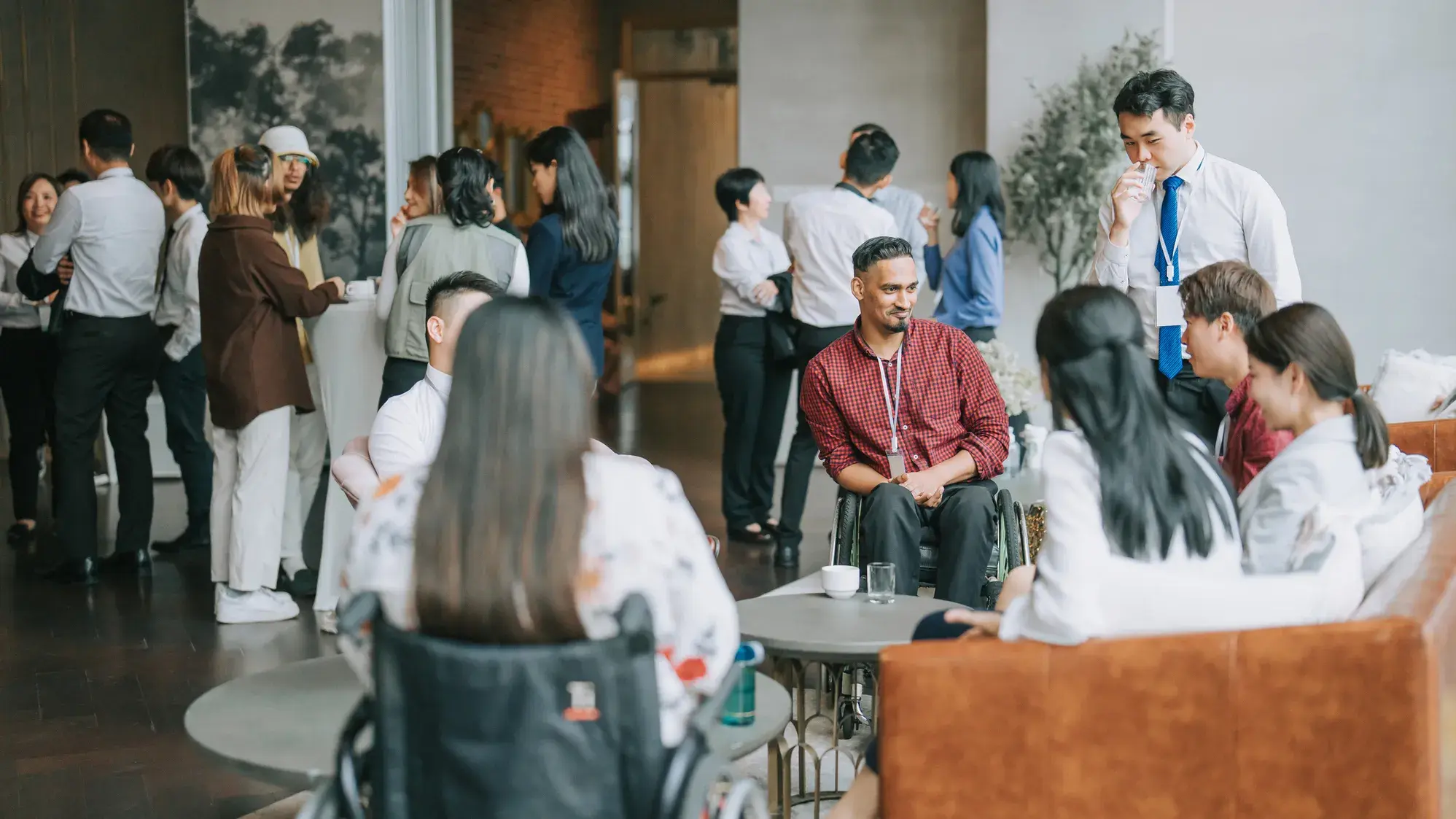 Group of men and women networking in an event space well lit