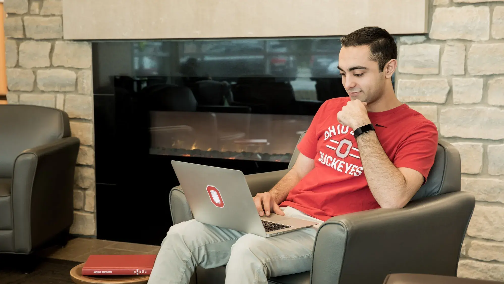 Student wearing Ohio State shirt using laptop