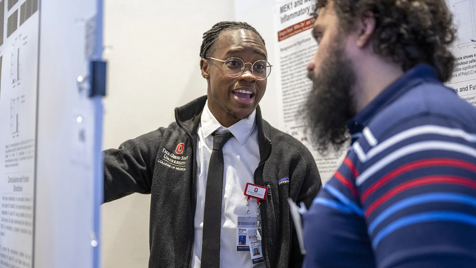 Man presenting poster to attendee