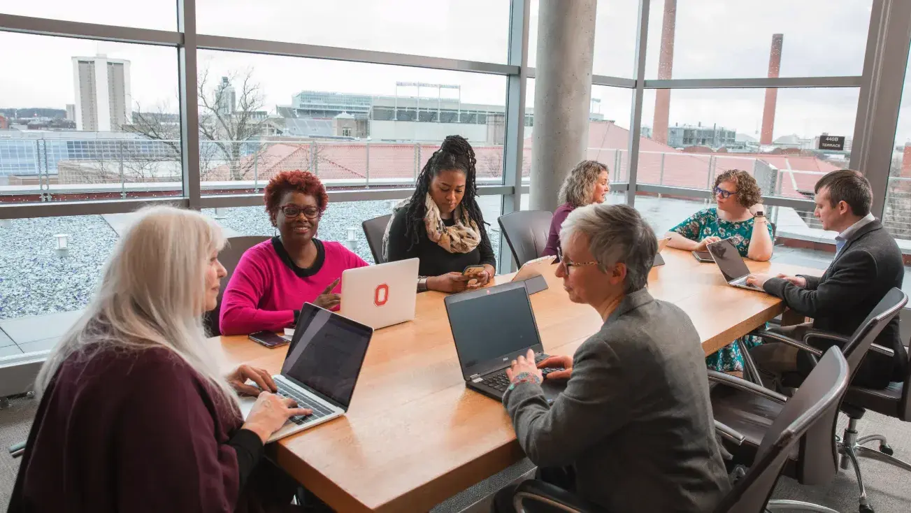 People sitting at table with laptops learning together